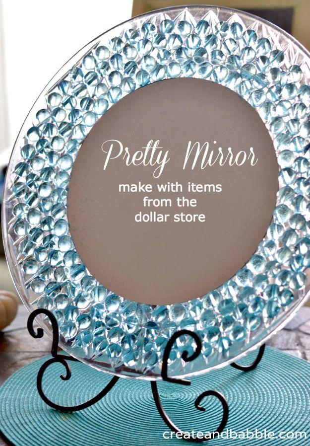 Pretty mirror graphic showing a round mirror ringed with clear glass gems on a black stand and teal mat