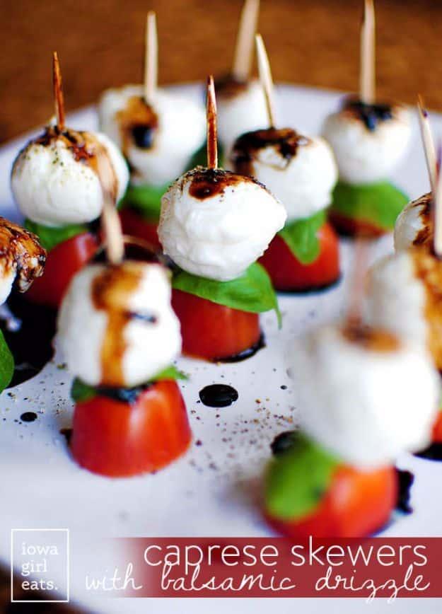 Caprese skewers with cherry tomatoes, mozzarella and basil on toothpicks finished with balsamic glaze