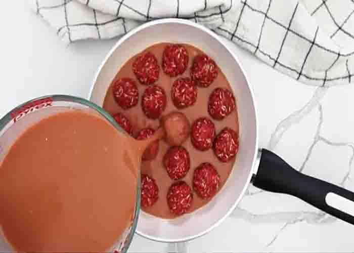 Adding the sauce to the porcupine meatballs