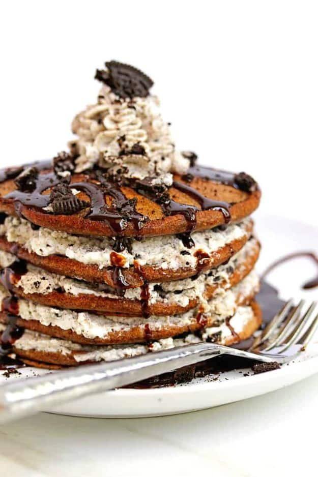 Oreo pancakes layered with cookies and cream whipped cream, chocolate sauce and crushed Oreos on the top