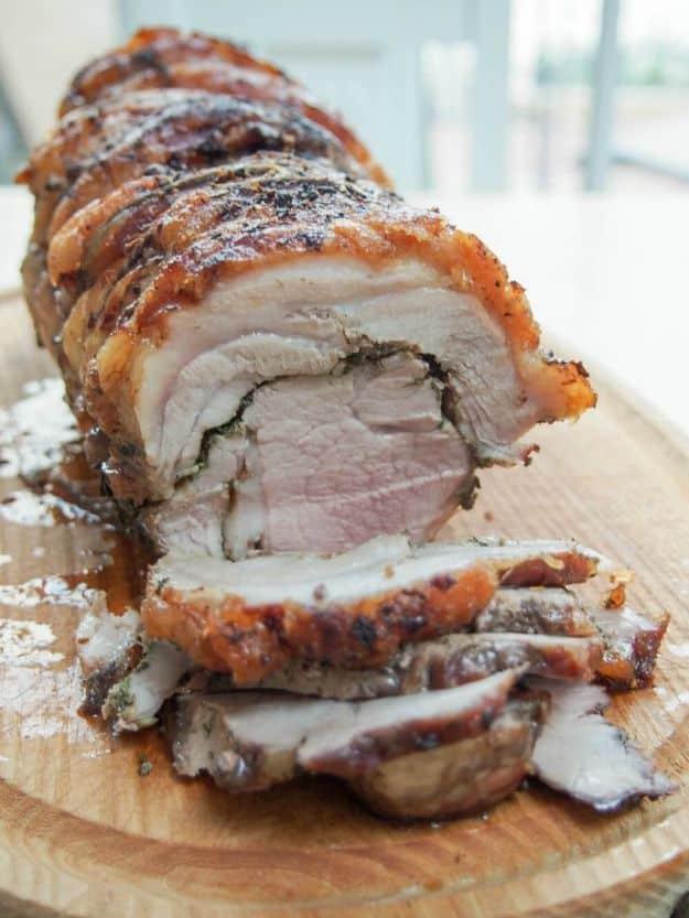 Porchetta, a rolled and tied Italian pork roast with crisp scored skin and a fennel and fresh herb paste