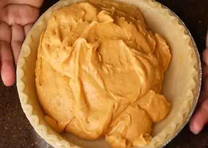 Adding the sweet potato filling to the pie shell