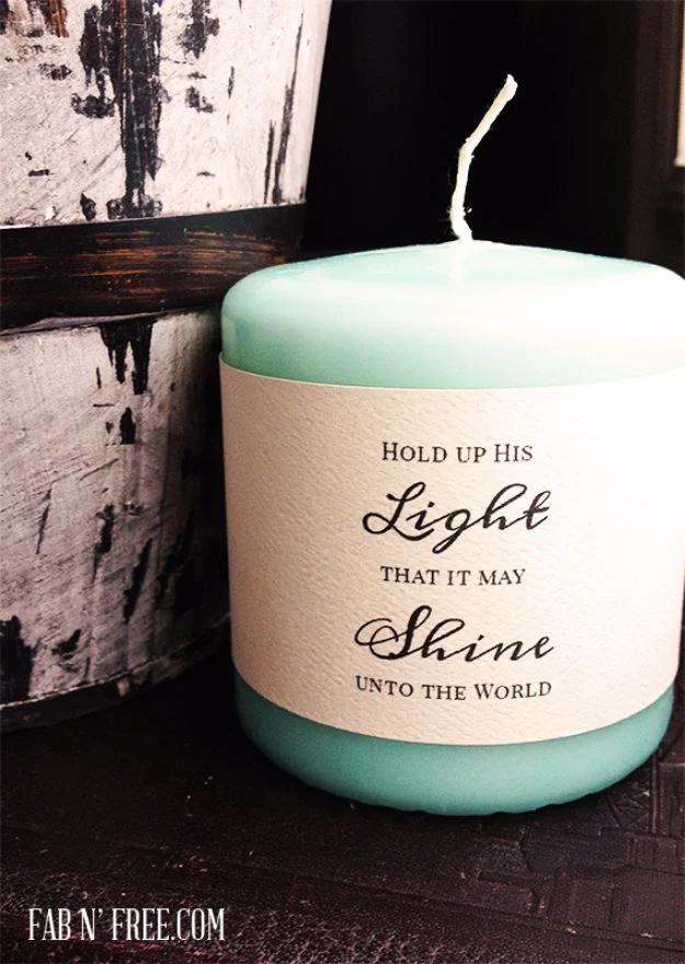 Free printable candle wrap label in cream script wrapped around a mint pillar candle on weathered dark wood