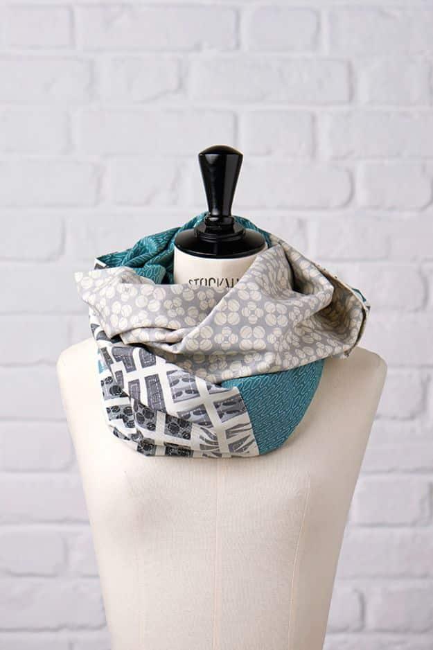 Fat quarter infinity scarf in gray, cream and teal prints looped twice around a dress form against white brick