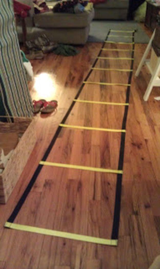 Homemade agility ladder in black and yellow nylon webbing laid out along a hardwood living room floor