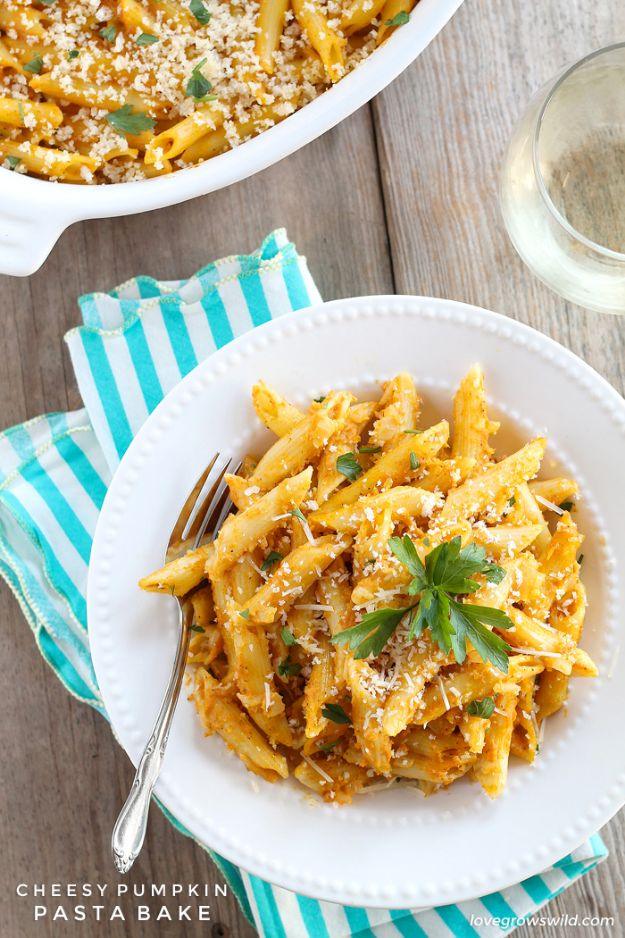White plate of penne pasta in creamy orange pumpkin sauce with crumb topping and parsley, teal cloth