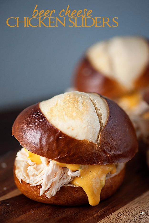 Slow cooker chicken piled onto soft pretzel rolls and finished with a beer cheese sauce poured over top