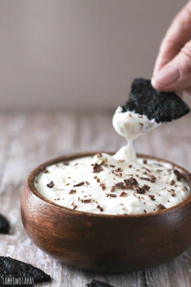 Oreo cheesecake dip in a bowl with crushed chocolate cookie pieces through a creamy white cheesecake filling