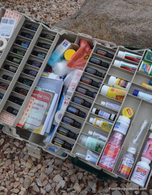 Open fishing tackle box on gravel with lift out trays filled with bandages, medicines and first aid supplies