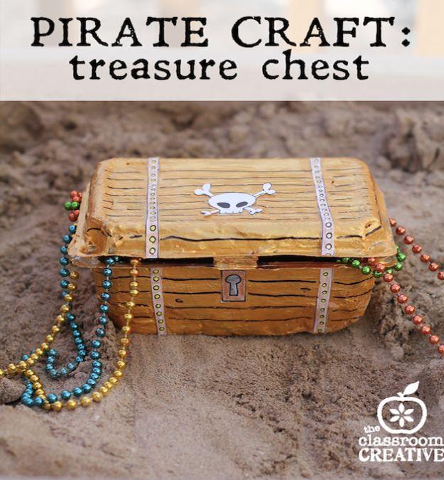 Gold papier mache pirate treasure chest sitting in sand with beaded necklaces spilling out, under a typeset title