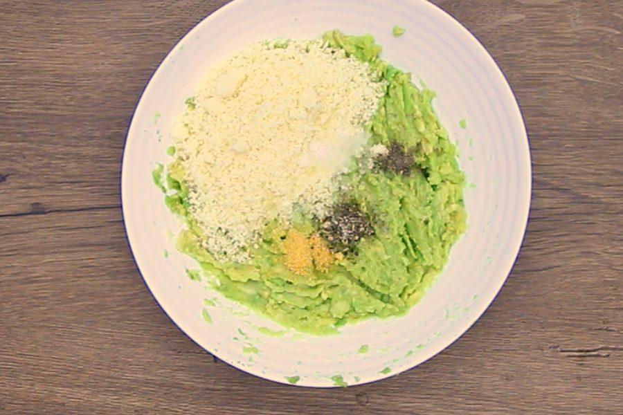 Mashed avocado with grated parmesan and seasoning on a plate for avocado chips