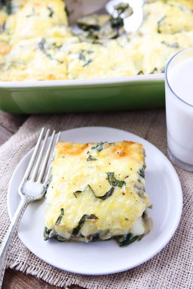 Spinach artichoke egg casserole in a green baking dish with a cut square plated beside a glass of milk