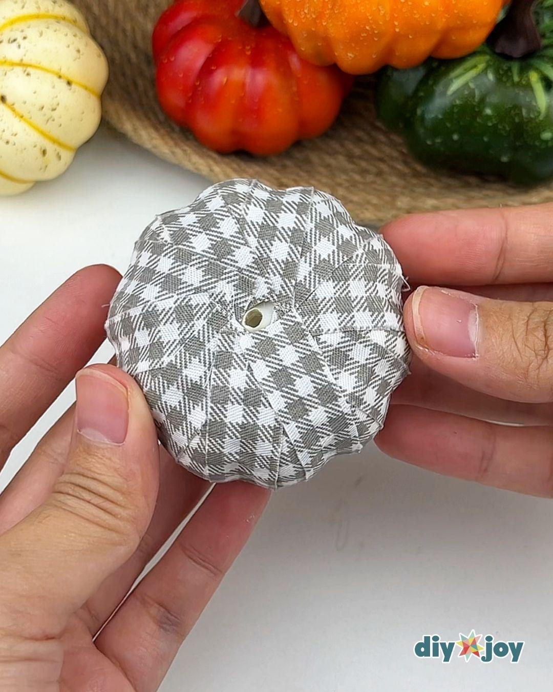 Fabric Pumpkins - top down view of a faux pumpkin fully covered in gray gingham strips with the empty stem hole in the center