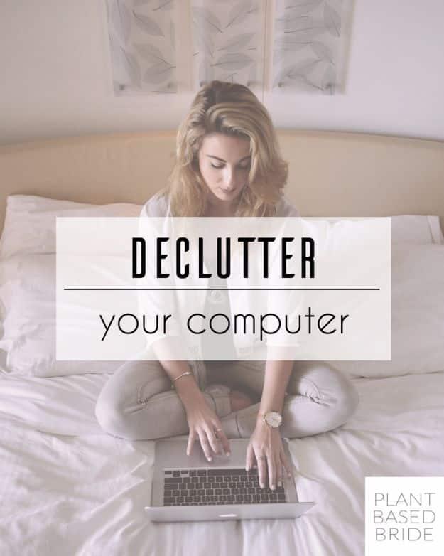 Woman sitting cross legged on a bed typing on a laptop, with the words declutter your computer over the photo