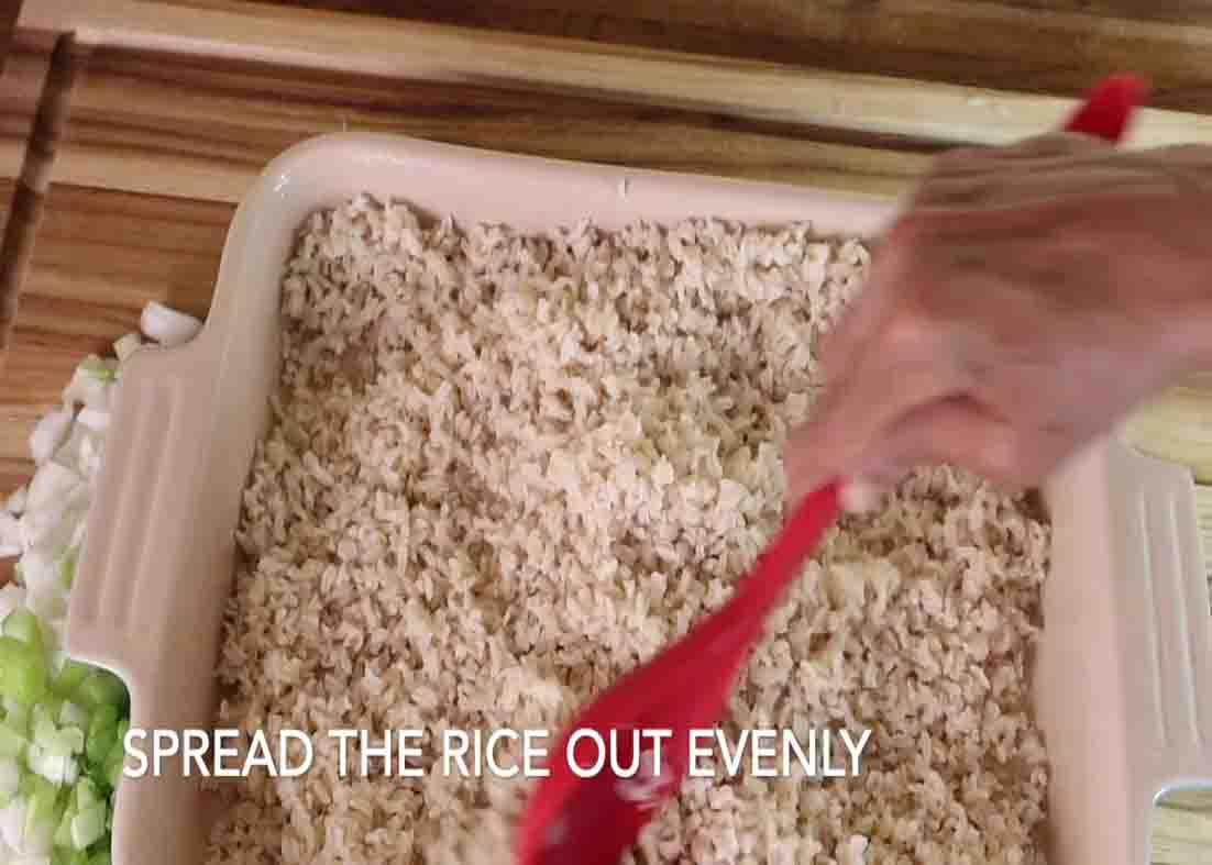 Adding some cooked rice on the casserole for the seafood coastal casserole recipe