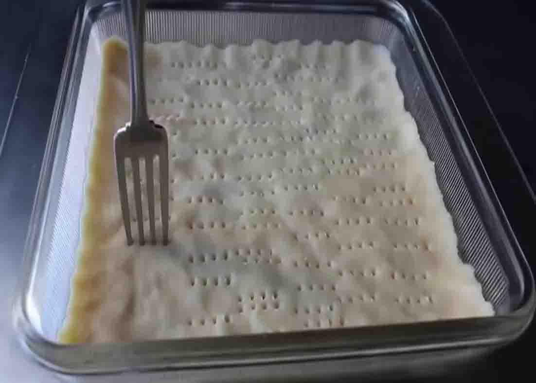 Poking holes to the shortbread base of the lemon bars