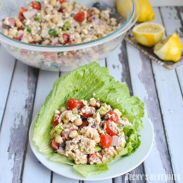Mediterranean tuna and chickpea salad in a glass bowl with a filled romaine lettuce wrap on a white plate