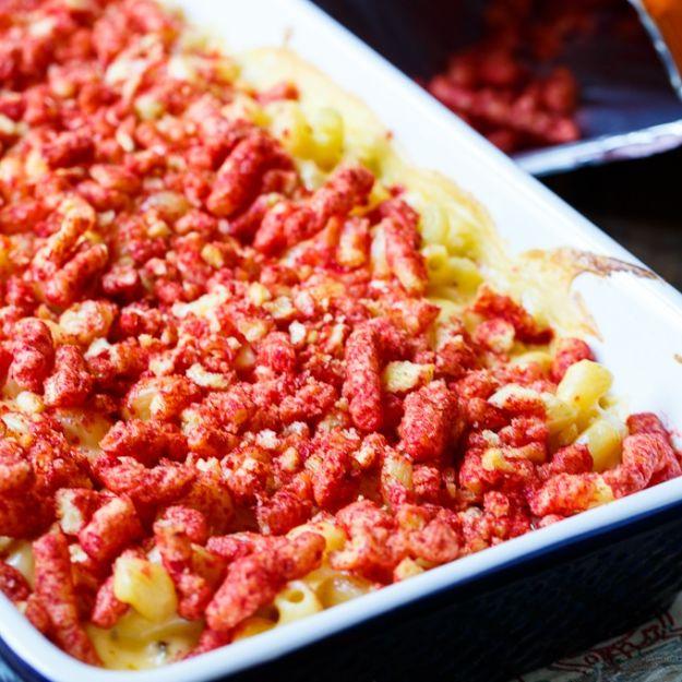 Flamin Cheetos mac and cheese in a white baking dish under a thick layer of crushed bright red Cheetos