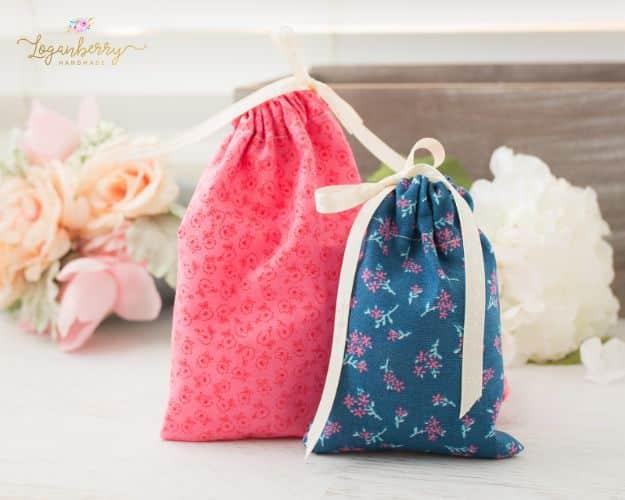Five minute fabric gift bags in coral and teal floral cotton tied with cream ribbon, pale roses and hydrangea behind