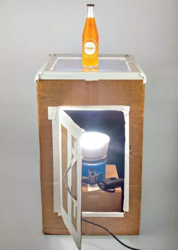 DIY light table, a cardboard box with a translucent top holding an orange soda bottle, a lamp inside firing up