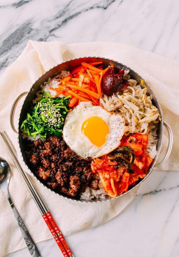 Korean beef bibimbap bowl with rice, seasoned ground beef, bean sprouts, carrot, kimchi and a fried egg
