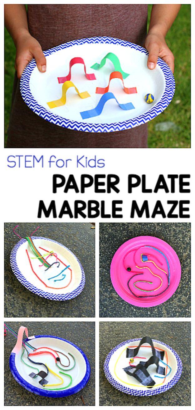 Paper plate marble maze, a child holding a chevron rimmed plate with colored paper arches, above four finished maze plates