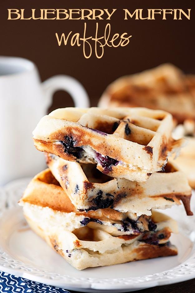Blueberry muffin waffles stacked on a plate, golden with blueberries baked through, butter melting on top