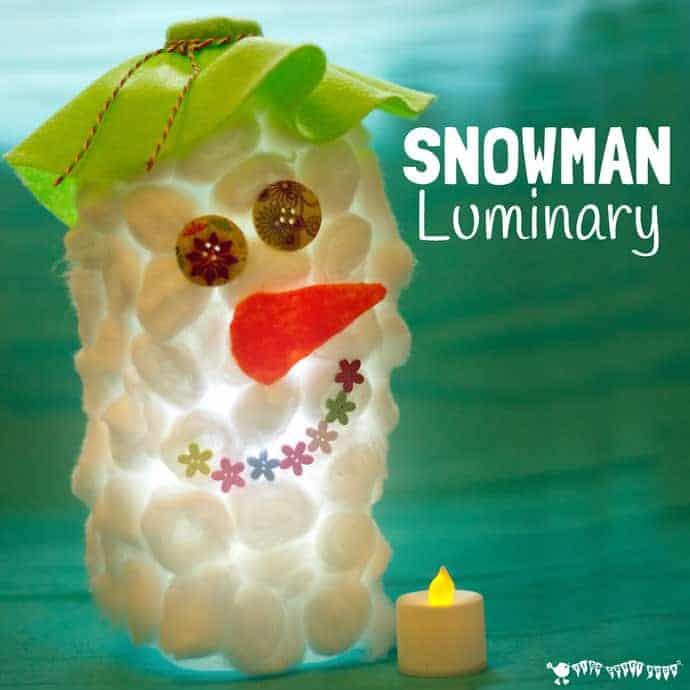 A snowman luminary made from a milk jug covered in cotton balls with button eyes and a felt hat, glowing beside a tea light