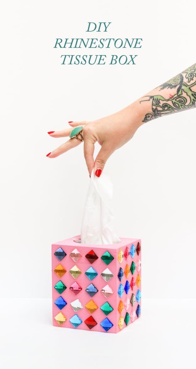 Pink wooden tissue box cover studded with multicolored square rhinestones, with a hand pulling a tissue out