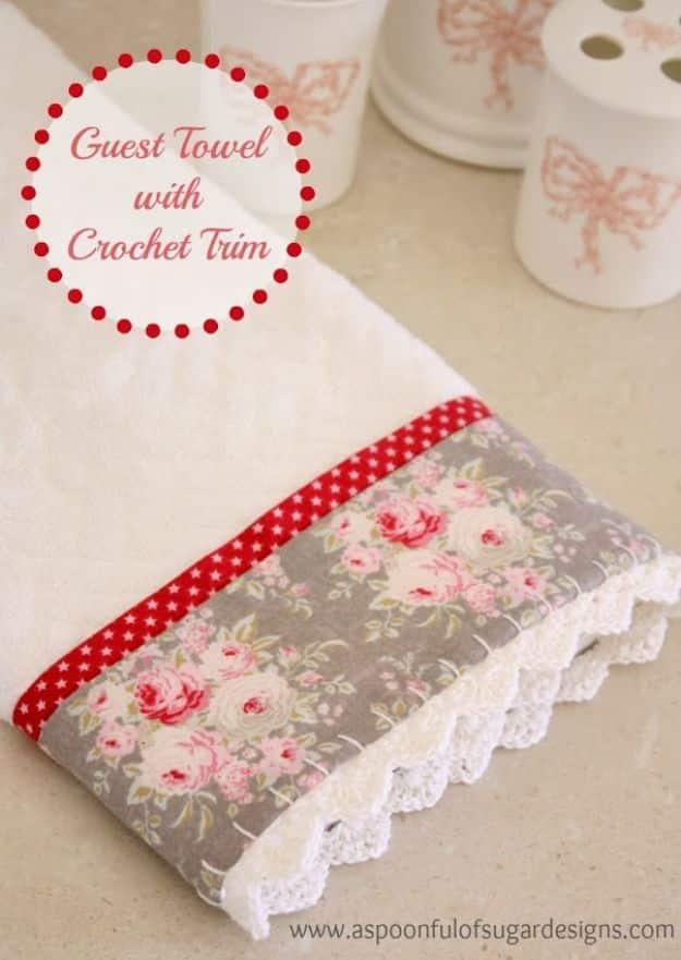 Guest towel banded in a gray and pink rose print with a red star ribbon and a cream hand crocheted scallop