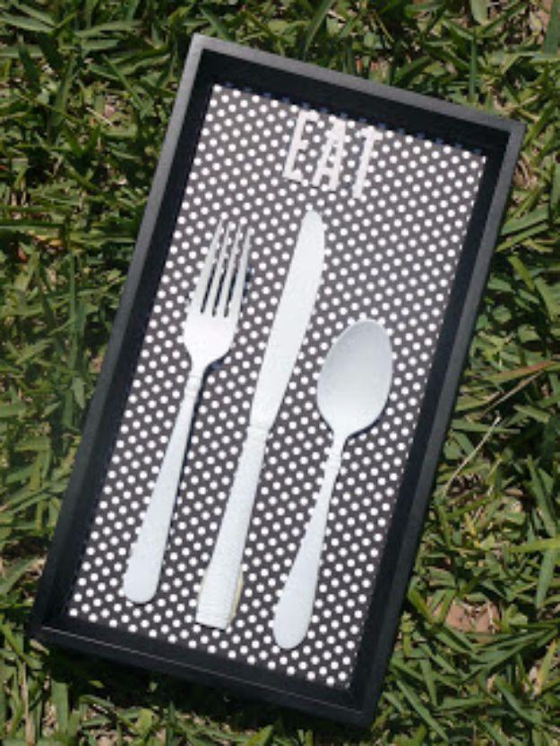 Black framed polka dot paper with a white painted fork, knife and spoon and chipboard letters spelling EAT