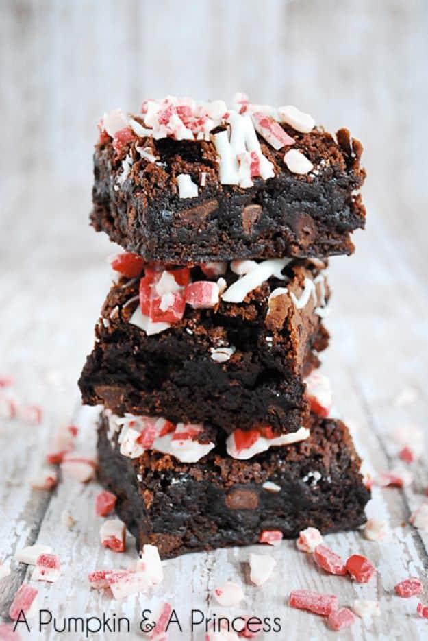Triple chocolate peppermint brownies stacked with crushed red and white peppermint pieces over the top