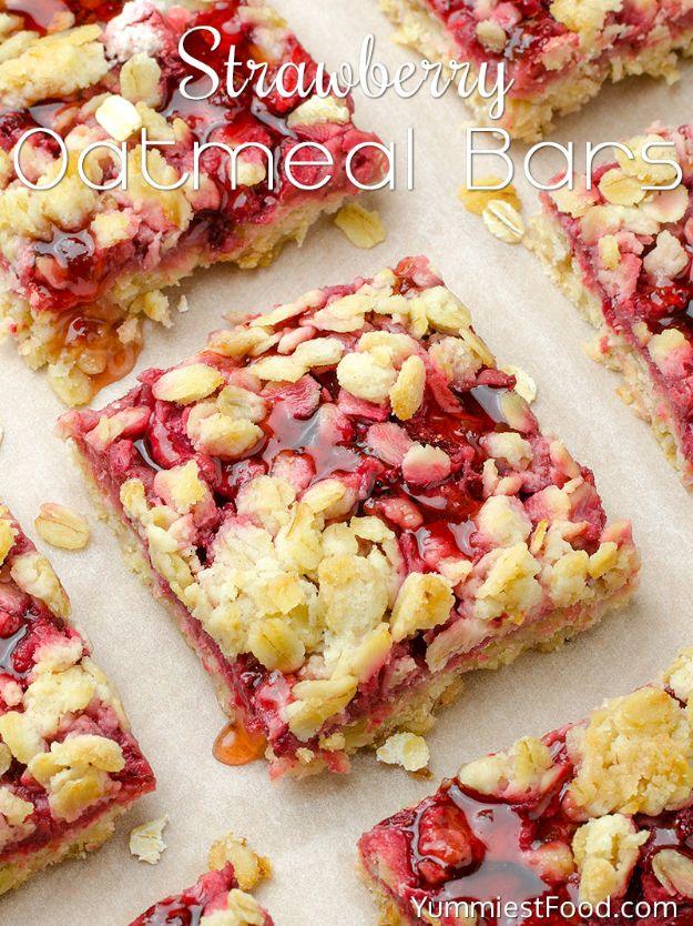 Strawberry oatmeal bars cut into squares on parchment with a crumbly oat topping and red berry filling