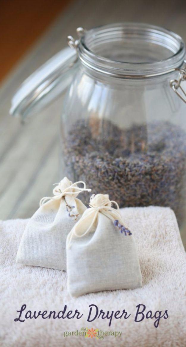 Two white muslin lavender dryer bags on a folded white towel beside a glass jar of dried lavender buds