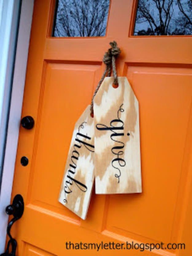 Giant wood tags cut from board with twine hangers and painted lettering used as rustic Thanksgiving decor