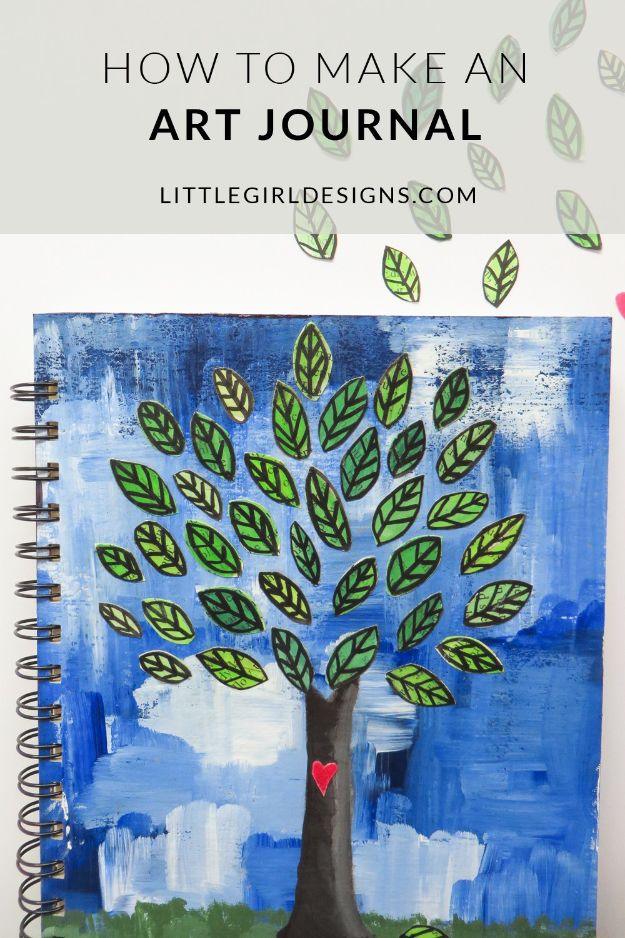 Art journal pin graphic reading How To Make An Art Journal over a painted blue cover with a green leafy tree and a red heart
