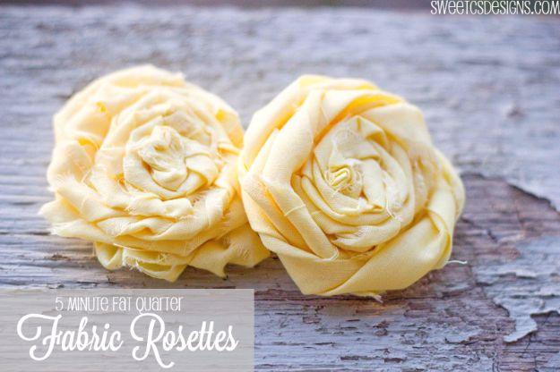Quilting scraps fabric rosettes in pale yellow cotton with raw rolled edges sitting on a weathered grey board