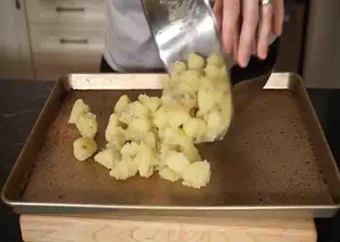 Laying the duck fat potatoes in a baking sheet