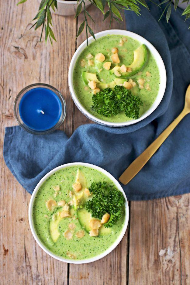 Detox broccoli soup blended smooth with coconut milk, topped with avocado, parsley and crushed macadamia nuts