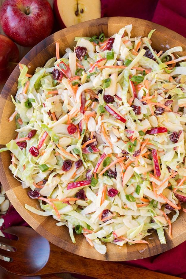 Apple cranberry almond coleslaw with shredded cabbage, carrot matchsticks and sliced almonds in a bowl