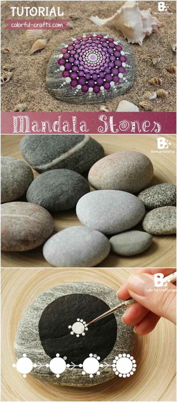 Purple and white dot mandala painted on a gray stone lying in sand among seashells, above plain beach pebbles