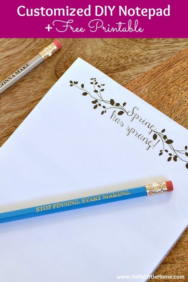 Three notepads stacked at an angle with a printed personalized name across the top sheet and a gold pen beside them