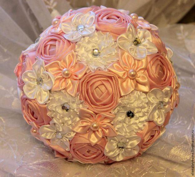Rose brooch bouquet of peach and cream satin ribbon roses with pearl centers packed into a domed bouquet