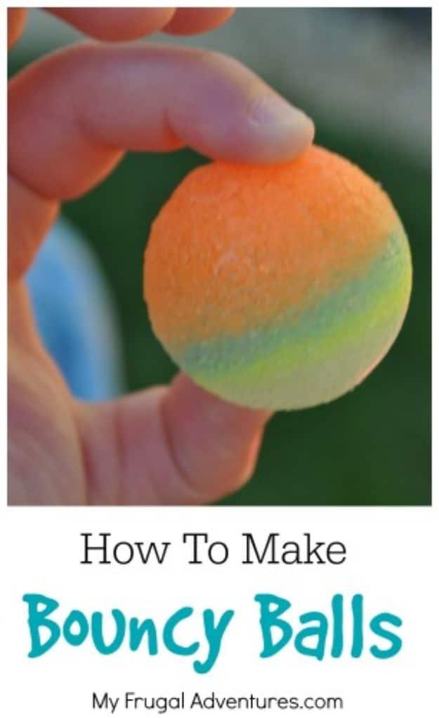Orange and yellow homemade bouncy ball held between two fingers after being rolled from glue and borax