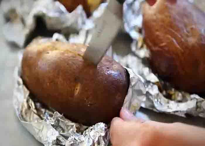 Adding toppings to the baked potatoes