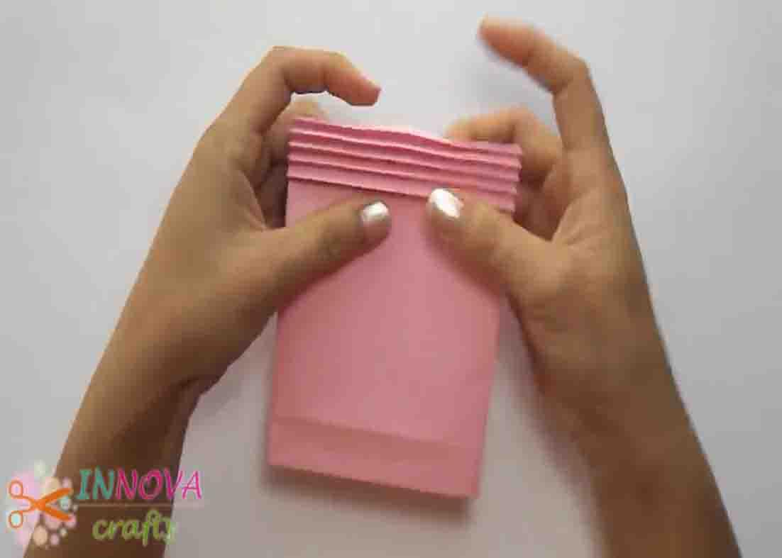 Making little folds on top of the paper gift bag