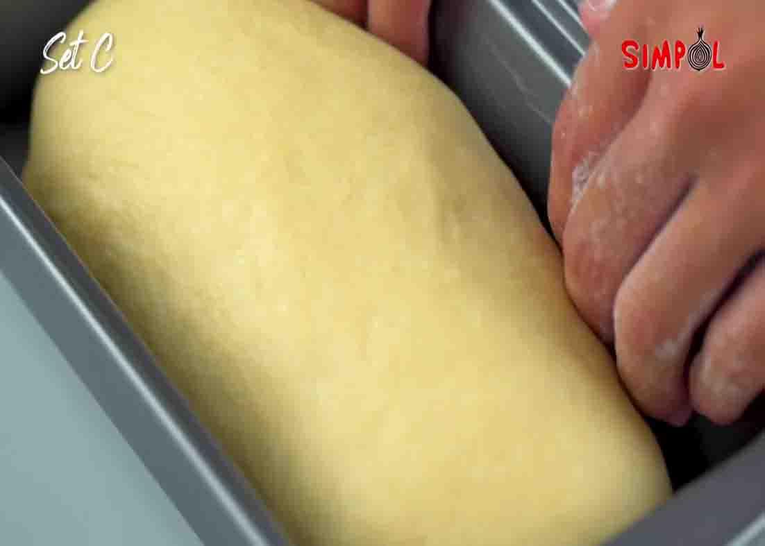 Putting the dough to the greased loaf pan