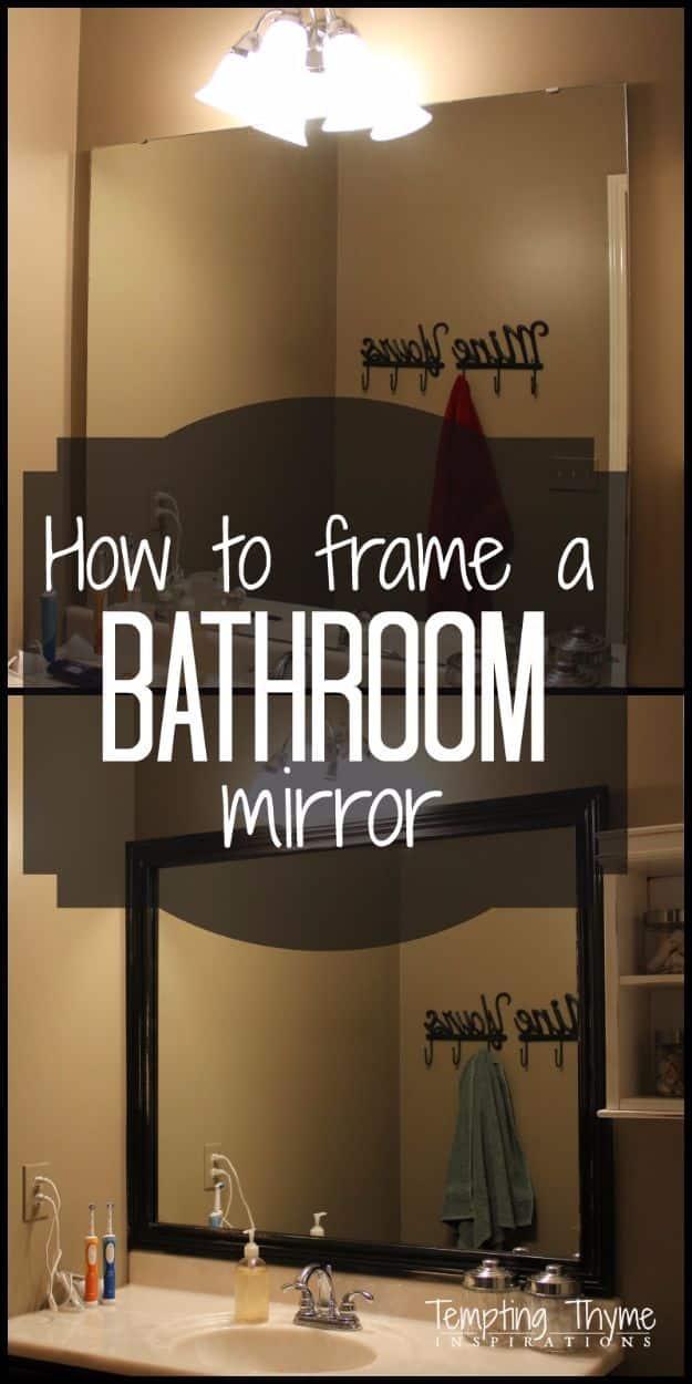 Graphic reading How to frame a BATHROOM mirror, showing a dark wood framed mirror above a lit bathroom vanity