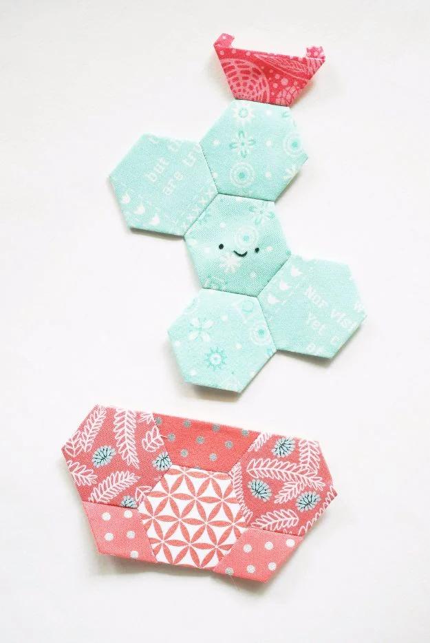 Happy cactus English paper piecing block, mint hexagons with a stitched smiley face in a coral fabric pot