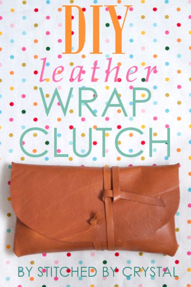 Tan leather clutch with a rounded flap wrapped with a thin leather strap tied in a knot on a polka dot cloth
